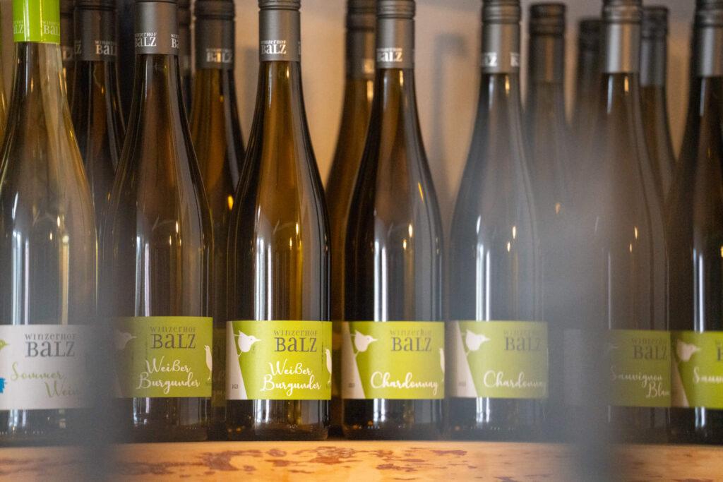 Mehrere Flaschen Weißwein in einem Regal von Weineck Wallroth